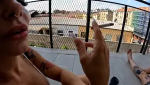 Two girlfriends smoke a cigarette