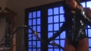 Busty latex vixen dominates young dark skinned babe